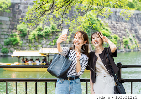 女子旅  大阪城の水堀で自撮りする女性 103331225