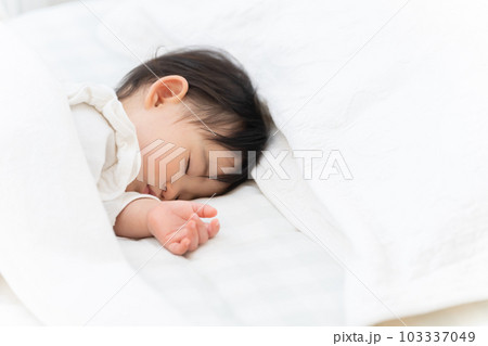ベッドで昼寝する生後9ヶ月の赤ちゃん ベッドで昼寝する生後9ヶ月の赤ちゃん 103337049