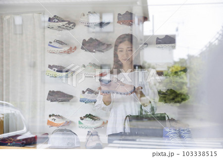スポーツアパレルショップで買い物をする若い女性 スポーツアパレルショップで買い物をする若い女性 103338515