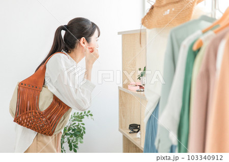 アクセサリーショップ・雑貨店でピアス・イヤリングを選ぶ女性客 103340912