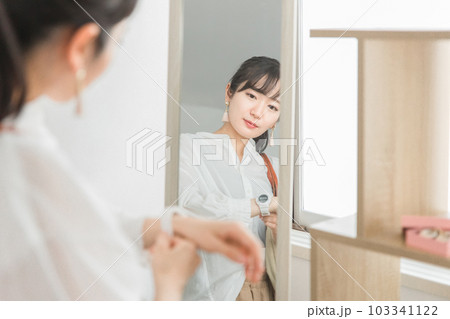 アクセサリーショップ・雑貨店で腕時計を選ぶ鏡越しの女性客 103341122