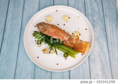Plate of fried small fish red mullet with green asparagus 103341299
