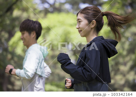 屋外でランニングをする若い男女 屋外でランニングをする若い男女 103342164