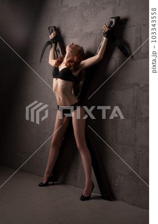 Sexy naked woman with hands tied to cross BDSM 103343558