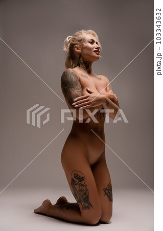 Sensual naked blonde tattoo model in studio Sensual naked blonde tattoo model in studio 103343632