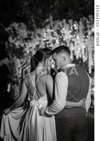 couple of newlyweds on the evening illuminated arch 103346316