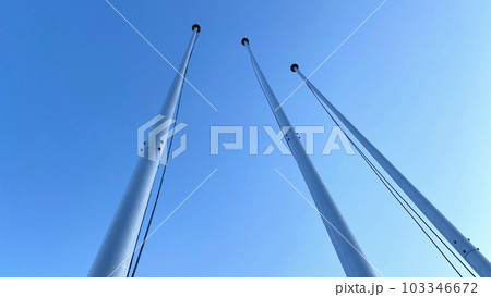 見上げる3本のフラッグポール_青空背景 103346672