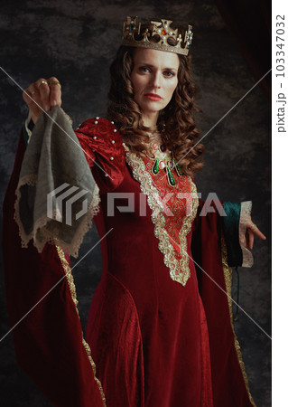 medieval queen in red dress with handkerchief and crown medieval queen in red dress with handkerchief and crown 103347032