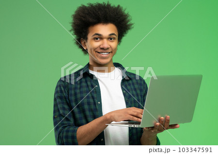 Young african american guy in checkered shirt with a laptop 103347591