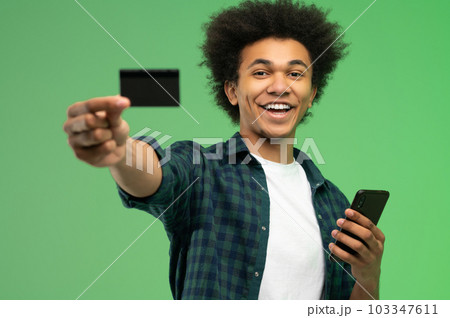 African american young guy with smartphone and credit card in hands 103347611