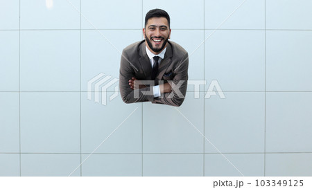 Handsome smiling business man in a suit standing with his arms crossed. Handsome smiling business man in a suit standing with his arms crossed. 103349125