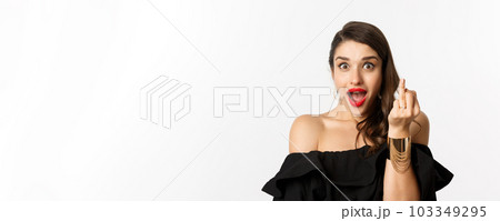 Excited young woman showing finger with engagement ring, got engaged, she said yes, standing over white background 103349295
