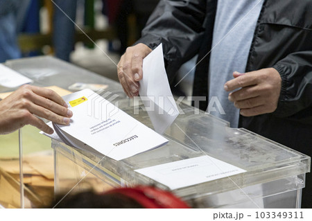 Elections. Hand of a person who votes at the polls during the elections. Envelope with the ballot on election day to choose your candidate. Envelope with ballot. Election image. Elections 2023. Elections. Hand of a person who votes at the polls during the elections. Envelope with the ballot on election day to choose your candidate. Envelope with ballot. Election image. Elections 2023. 103349311