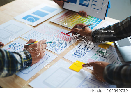 UX developer and ui designer brainstorming about mobile app interface wireframe design with customer breif and color code at office. with virtual icon. 103349739