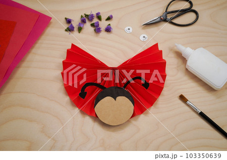 Step by step diy process handmade craft Ladybug made of paper and flowers. Step 7- glue the black mustache. Red love symbol. 103350639