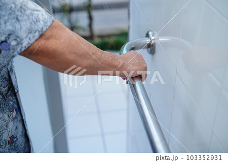 Asian elderly woman patient use toilet bathroom handle security in nursing hospital, healthy strong medical concept. 103352931