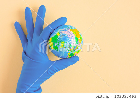 Earth globe in hands in blue protective glove on a clean. The concept of protecting nature, ecology and global peace. COVID-19 pandemic Earth globe in hands in blue protective glove on a clean. The concept of protecting nature, ecology and global peace. COVID-19 pandemic 103353493