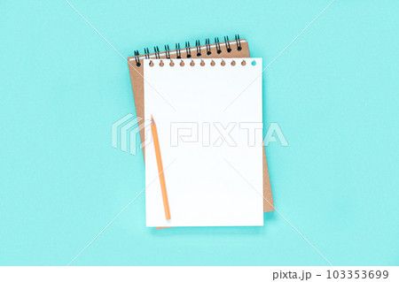 Notebook with pencil. School notebook on light blue background, spiral notepad on table. Top view of open notebook with blank pages, office notepad flat lay. White Page for your write. Copy Space Notebook with pencil. School notebook on light blue background, spiral notepad on table. Top view of open notebook with blank pages, office notepad flat lay. White Page for your write. Copy Space 103353699