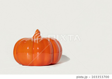Ceramic pumpkin on white background. Decorative orange glass pumpkin isolated on white. Autumn minimal layout concept. Halloween, thanksgiving, creative sale banner. Trendy fall seasonal decoration Ceramic pumpkin on white background. Decorative orange glass pumpkin isolated on white. Autumn minimal layout concept. Halloween, thanksgiving, creative sale banner. Trendy fall seasonal decoration 103353700