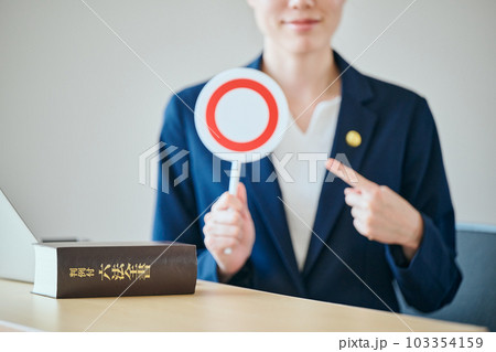 まるばつプレートを指さす若い女性弁護士 103354159