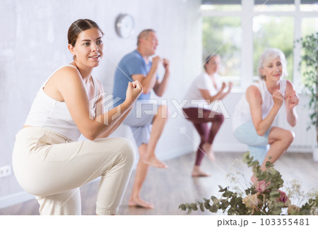 Group of happy mature sports women and man in activewear exercising dynamic dancing movemens in gym studio Group of happy mature sports women and man in activewear exercising dynamic dancing movemens in gym studio 103355481
