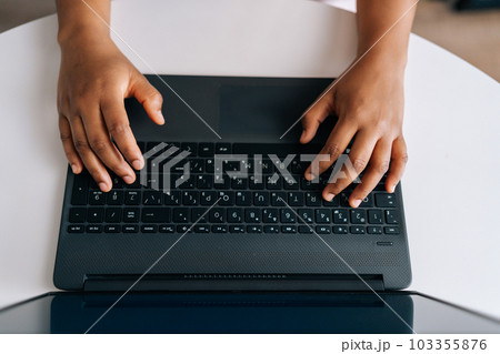 Closeup high angle view hands of unrecognizable African American businesswoman press on keyboard keys, typing on laptop keyboard working online. Black female freelancer working from remote home office 103355876