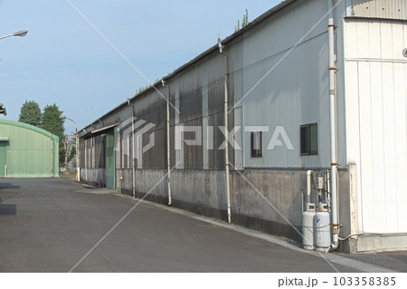 晴れの日に佇む工場と倉庫 103358385