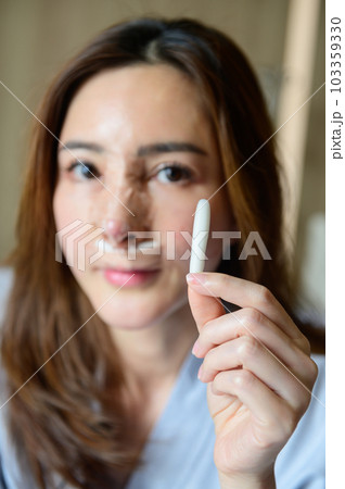 Woman showing old silicone from her nose after revision rhinoplasty 103359330