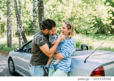 Mom, dad and little son in a convertible car. Summer family road trip to nature Mom, dad and little son in a convertible car. Summer family road trip to nature 103359566