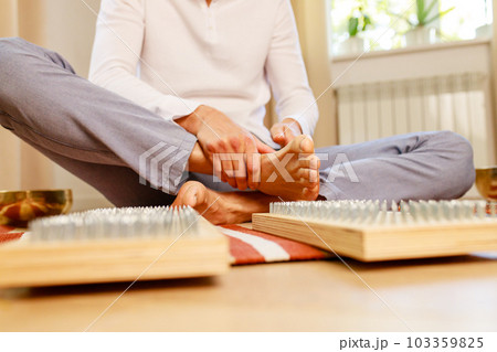 morning yoga practice with sadhu nails. mans foot on the wooden desk with sharp metal nails morning yoga practice with sadhu nails. mans foot on the wooden desk with sharp metal nails 103359825