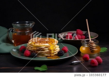 pancake spread with honey and raspberry on a plate on a dark background pancake spread with honey and raspberry on a plate on a dark background 103360177