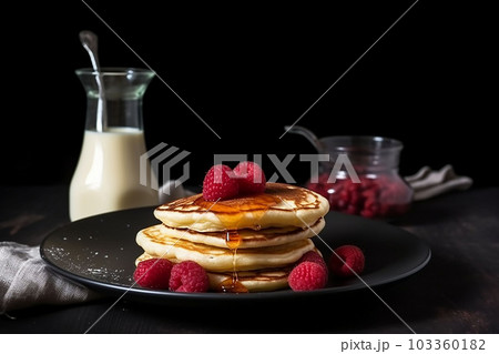 pancake spread with honey and raspberry on a plate accompanied with milk pancake spread with honey and raspberry on a plate accompanied with milk 103360182