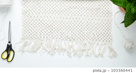 Creative hobby handmade macrame for home decoration. Weaving macrame at home. Tools and materials for macrame weaving. Flat lay, top view Creative hobby handmade macrame for home decoration. Weaving macrame at home. Tools and materials for macrame weaving. Flat lay, top view 103360441