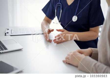 Doctor and patient discussing current health questions while sitting at the table in clinic, jast hands closeup. Medicine concept 103360983