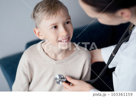 Doctor and happy smiling child boy patient at home medical inspection. Medicine, healthcare concepts Doctor and happy smiling child boy patient at home medical inspection. Medicine, healthcare concepts 103361159