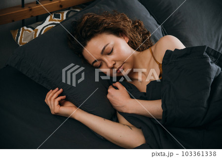 Tranquil young woman sleeping in bed Sleep on side 103361338