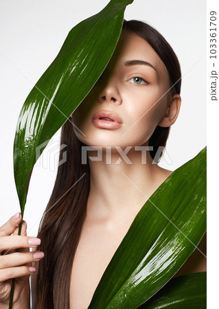 beautiful girl with palm leaves. Beautiful young woman with Make-up beautiful girl with palm leaves. Beautiful young woman with Make-up 103361709