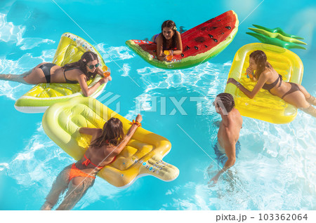 Friends in swimsuit in the pool getting a tan 103362064