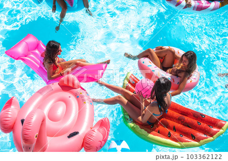 Friends in swimsuit in the pool getting a tan 103362122