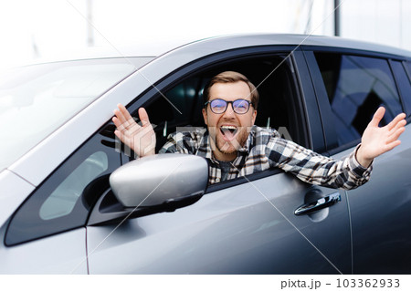 Man customer sitting in car salon and smiling, choosing auto and wanting to buy new automobile in showroom dealership store. Car sales concept. 103362933