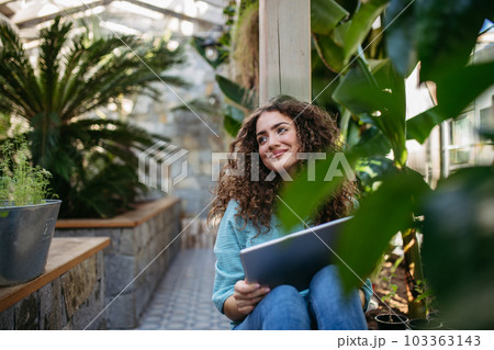 Portrait of young woman in botanical garden. 103363143