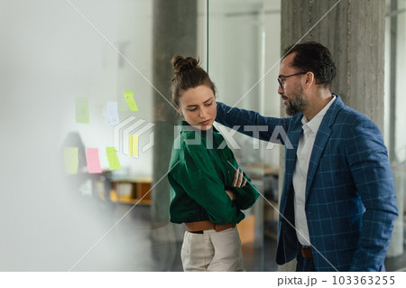 Mature man abusing his younger colleague, concept of harassment at workplace. 103363255