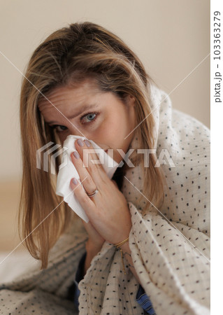 Portrait of young sick woman sneezing at bedroom. Portrait of young sick woman sneezing at bedroom. 103363279