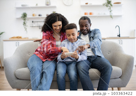 Couple with kid playing video game on phone online 103363422