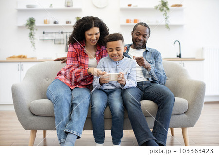 Couple with kid playing video game on phone online 103363423