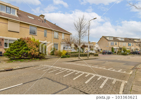 an empty street with houses in the background and cars parked on the side of the road next to each other buildings an empty street with houses in the background and cars parked on the side of the road next to each other buildings 103363621
