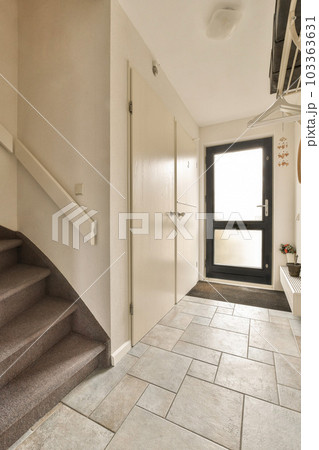 a hallway in a house with stairs leading up to the front door and an entryway on the right side 103363631