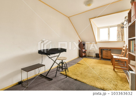 a room with a chair, desk and bookcases on the floor next to an open door that leads to a window a room with a chair, desk and bookcases on the floor next to an open door that leads to a window 103363632
