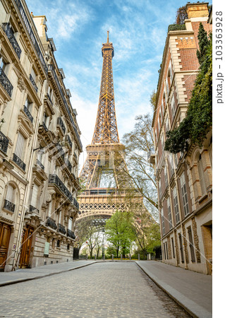 View of the Eiffel Tower from a nearby street full of residential buildings. Paris, France View of the Eiffel Tower from a nearby street full of residential buildings. Paris, France 103363928