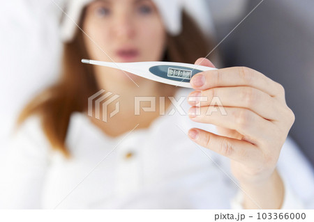 Close up: woman holding digital medical thermometer with high temperature  Stock Photo by ©Zyabich 386551076